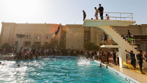 Seguidores del clérigo chií Al Sadr, este lunes, bañándose en la piscina del palacio presidencial de Bagdad