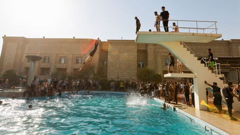 Seguidores del clrigo chi Al Sadr, este lunes, bandose en la piscina del palacio presidencial de Bagdad