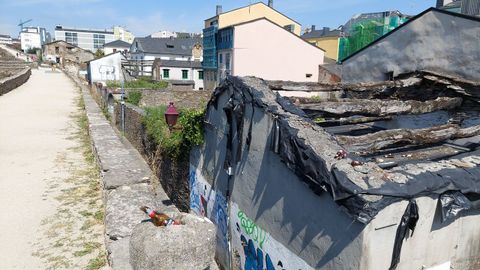 Botellas encima del adarve de la Muralla y de una casa abandonada entre palacios