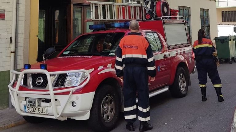Voluntarios de Protección Civil y un vehículo, delante del bar O'Xarmolo Novo, en el edificio donde se produjo el incendio