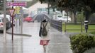 Una mujer se protege de la lluvia este sbado a media tarde en el centro de Monforte