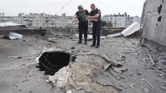 Agentes ucranianos inspeccionan los daos causados por un bombardeo ruso en un edificio de Jrkov