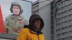 Un hombre camina ante una gran lona en apoyo del Ejrcito ruso en una calle de Mosc