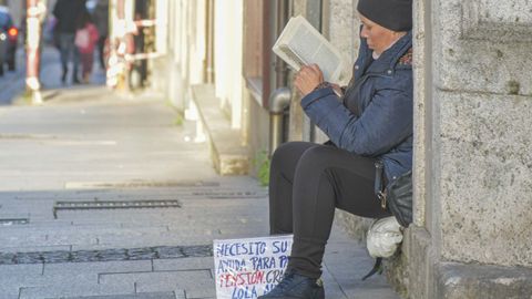 Lola pide en las calles de Lugo, pero siempre sostiene un libro entre las manos.