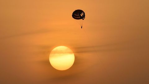 Una persona realizando paracaidismo al atardecer en Dubai