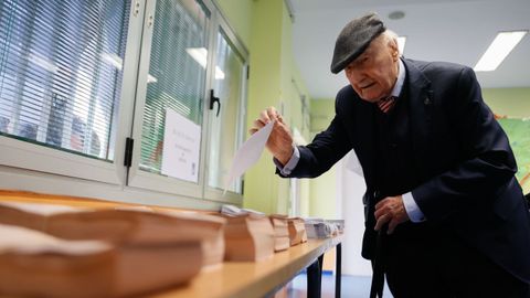 Un votante prepara su voto antes de depositar la papeleta electoral en una urna de un colegio electoral de Madrid