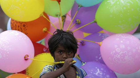 Un nio de 6 aos de edad vende globos en una calle de Bombay, India.