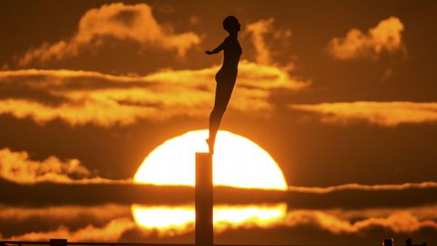 El sol sale detrs de la escultura Diving Belle en Scarborough, Reino Unido