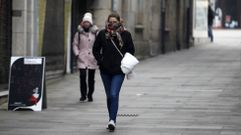 Dos mujeres caminan muy abrigadas por una calle del centro de Monforte en una fra maana de invierno, en una fotografa hecha en enero del 2019