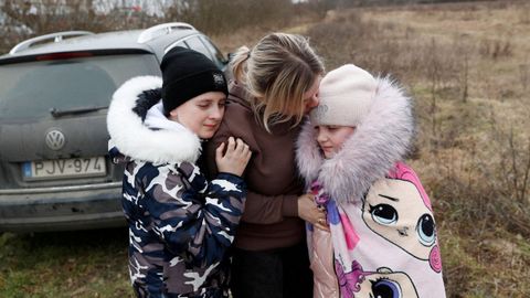 Anna Semyuk, de 33 años, abraza a sus hijos en el paso fronterizo de Beregsurany (Hungría). Los niños fueron entregados en el lado ucraniano de la frontera por el padre, que no está autorizado a cruzar.