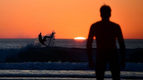 Un surfista compitiendo durante la puesta de sol en los World Surfing Games que se estn disputando en Biarritz (Francia).