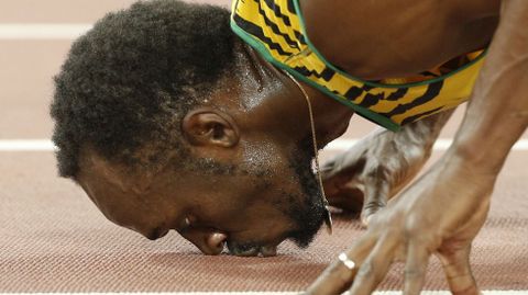 Usain Bolt besa el suelo despus de ganar la final de los 200 metros lisos en los campeonatos mundiales de atletismo