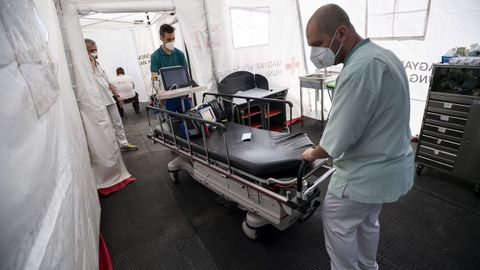 Profesionales sanitarios trasladan equipamiento diagnstico en un hospital de campaa en Budapest