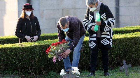 Varias personas con mascarilla visitando el cementerio de Pereir, en Vigo