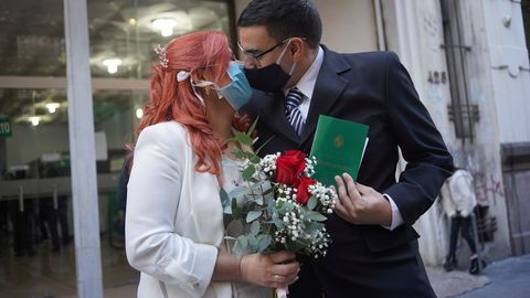 Laura Gmez y Martin Larzabal se besan mientras usan mscaras faciales despus de casarse en Montevideo