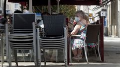 Una clienta con mascarilla en la terraza de una cafetera en el centro de Monforte