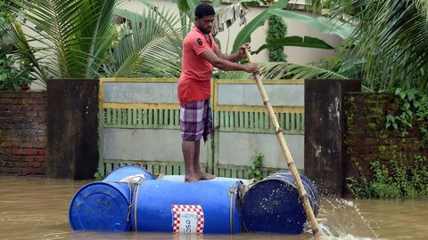 Un hombre usa una balsa hecha a mano para cruzar una calle inundada en Cochn, Kerala, India, hoy 10 de agosto de 2018. Al menos 20 personas han muerto en el sur de la India, la mayora de ellas a causa de los deslizamientos de tierra que han provocado las fuertes lluvias en la regin