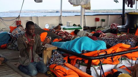 Un migrante reza a primera hora de la mañana del lunes a bordo del Open Arms, fondeado frente a Lampedusa