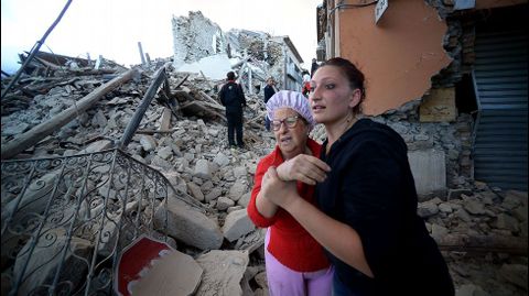 Una mujer sostiene a una anciana entre los escombros provocados por el terremoto de este mircoles en Amatrice (Italia)