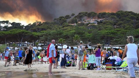 Gente en la playa observando el incendio en Francia