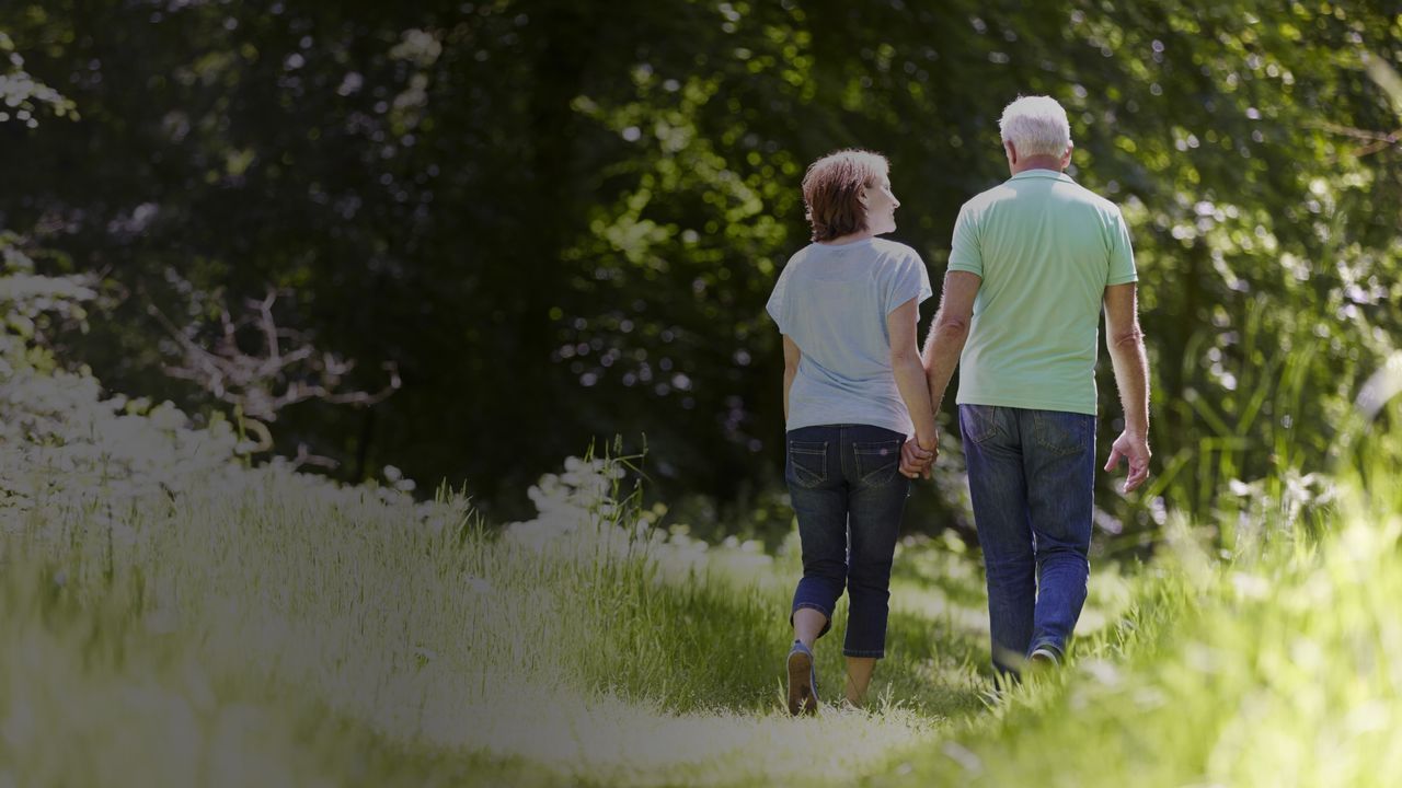Una pareja de personas mayores dando un paseo al aire libre