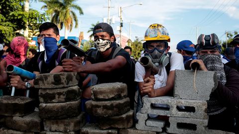 Manifestantes parados detrs de una barricada durante los enfrentamientos con la polica antidisturbios durante una protesta contra el gobierno del presidente de Nicaragua Daniel Ortega
