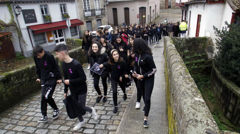 Estudiantes vestidas de negro en la cadena humana que unió este lunes los puentesnuevo y viejo en Monforte