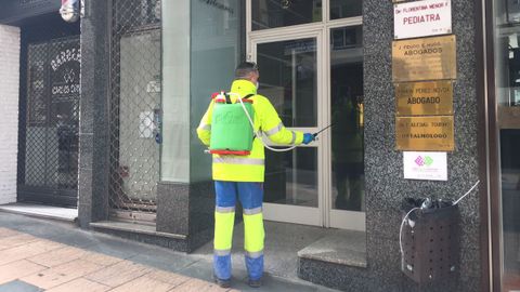 Trabajadores municipales desinfectando bancos, portales y otras zonas pblicas de Ourense
