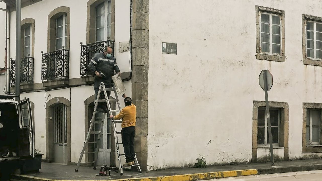 Operarios municipales sustituyendo la placa de Jos� Antonio por la de Xela Arias