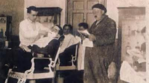 Peluquera Paulino en Arriondas en 1926. En primer plano, Paulino Cavielles Prieto afeitando