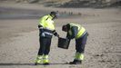 Dos operarios recogen plets de plstico en las playas de Asturias.