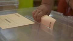 Una niña ayuda a sus mayores a votar en las elecciones generales en un colegio de Avilés