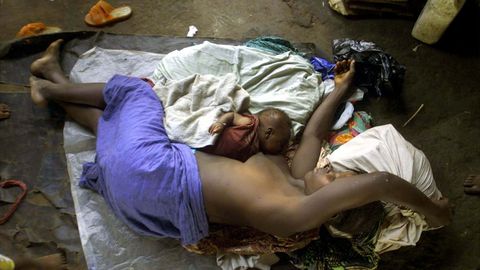 Una mujer de Sierra Leona yace indefensa en el suelo junto a su beb de seis semanas
