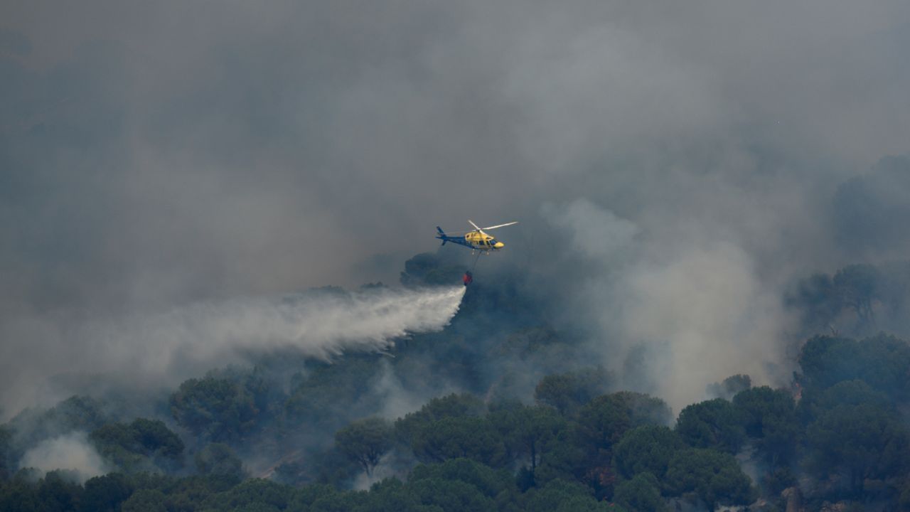 Un helicóptero arroja agua sobre el incendio de Cebreros, que sigue amenazando El Hoyo de Pinares