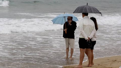 Gente con paraguas en la playa de Montalvo, Sanxenxo