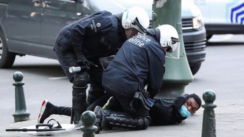 Policias belgas detienen a un manifestante durante las protestas del domingo