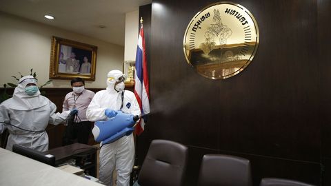 Varios trabajadores desinfectan las instalaciones del Gobierno de Bangkok