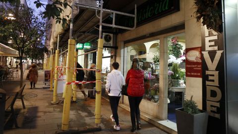   La tienda de telas resulta invisible por el andamio en la calle Rosalía de Castro
