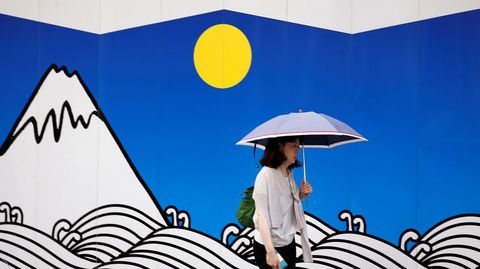 Una mujer pasa frente a un mural con una ilustracin del Monte Fuji en un distrito comercial de Tokio.