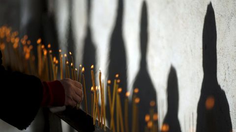 Sombras de personas que encienden velas durante la celebracin del Da de San Jorge en Georgia.