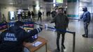 Un oficial de seguridad le entrega una mascarilla a un pasajero del metro de Estambul