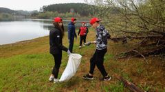 Varios voluntarios durante la jornada de limpieza de residuos de este viernes en el entorno del embalse del Umia, en Caldas