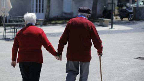 Una pareja mayor pasea agarrada de la mano por Oleiros (A Corua)