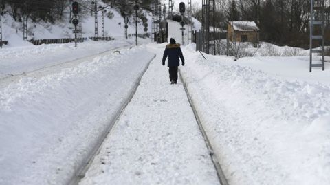 Un hombre camina entre las vas del tren heladas en Busdongo