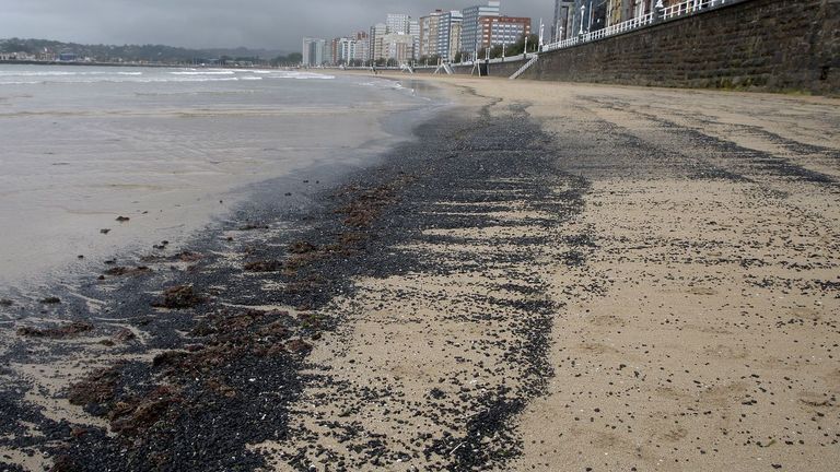 La playa de San Lorenzo ha amanecido este miércoles cubierta con carbón.