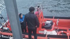 Sara Prez durante la llegada a puerto tras haber cado al agua al rescatar a uno de los nios arrastrados por la marea en Luarca. De espaldas, el patrn Carlos Rodrguez