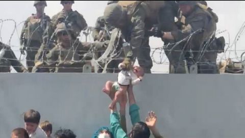 Un soldado estadounidense recoge a un bebé en la valla de la terminal del aeropuerto de Kabul, durante la caótica evacuación. 