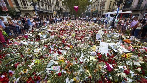 Ramos de flores, velas y peluches que presiden el mosaico de Joan Mir en la Rambla