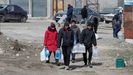 Un grupo de civiles carga botellas de agua en Mariúpol