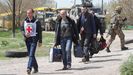 Civiles evacuados de la planta de Azovstal caminan tras un miembro de Cruz Roja en la localidad de Bezimenne, en la provincia de Donetsk